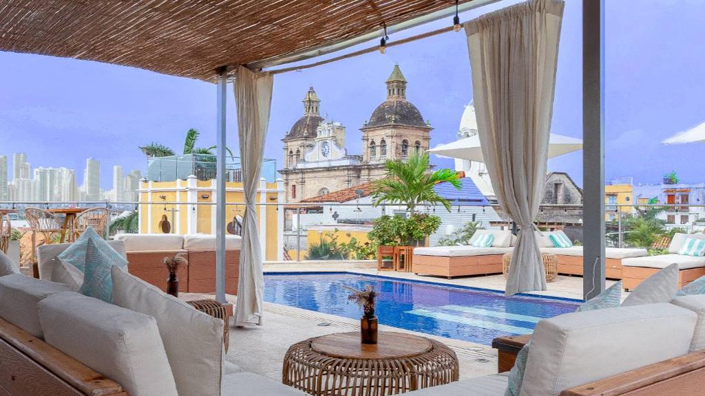 Terraza del Sophia Hotel en Cartagena con piscina y sofás bajo pérgola de madera